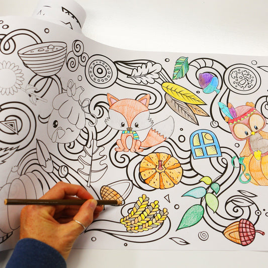 Hand coloring with a colored pencil on a long coloring sheet called a coloring roll by Artistic Chaos Ink with graphics of a fox, owl sitting on a pumpkin, feathers, corn, acorns and more