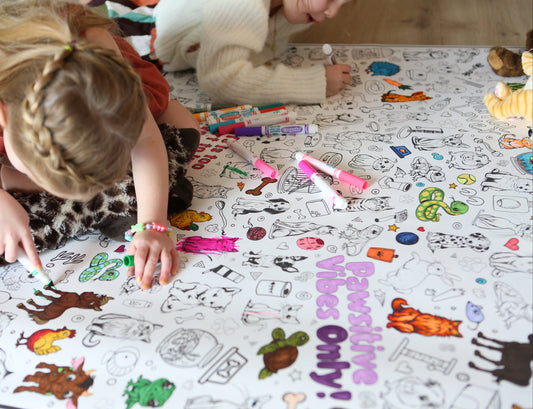 Child coloring on a large activity sheet with markers