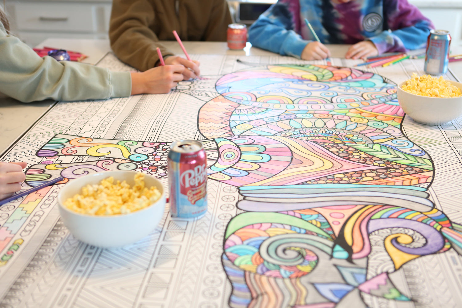 a giant coloring poster of a rhino being colored by a group of teenagers eating snacks like DP and popcorn.
