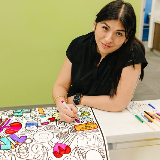 Woman nurse coloring a kidney coloring poster at a clinic with a green wall in the background