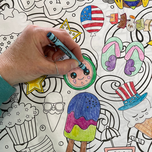 BBQ Coloring page being colored with various illustrations and a hand using a marker to color one of them.