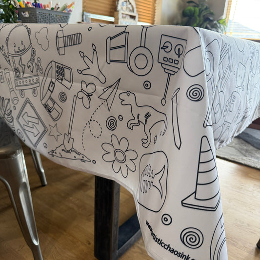 Coloring tablecloth with boy graphics in black line art on a wooden table