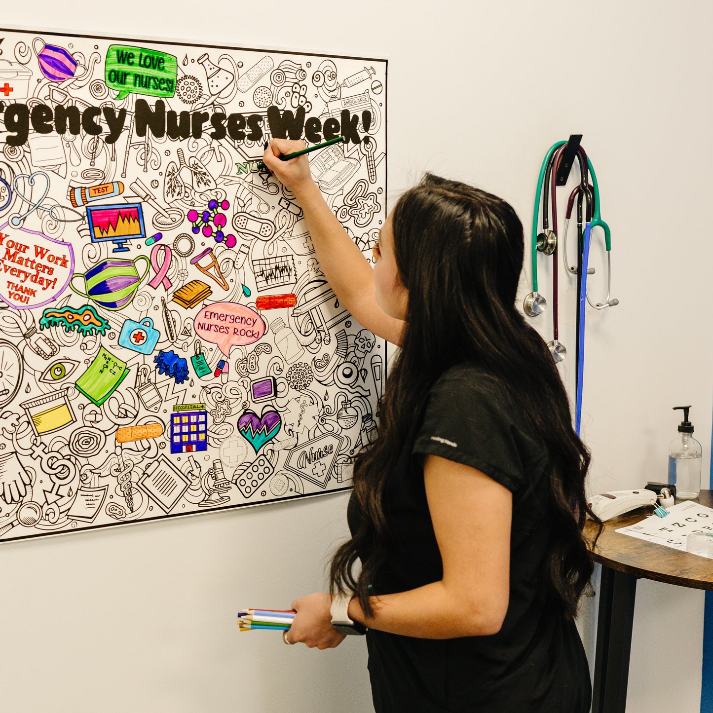Nurse coloring on a personalized nurses week poster.  A bulletin board with 'Nurses Week' decorations in a medical setting.