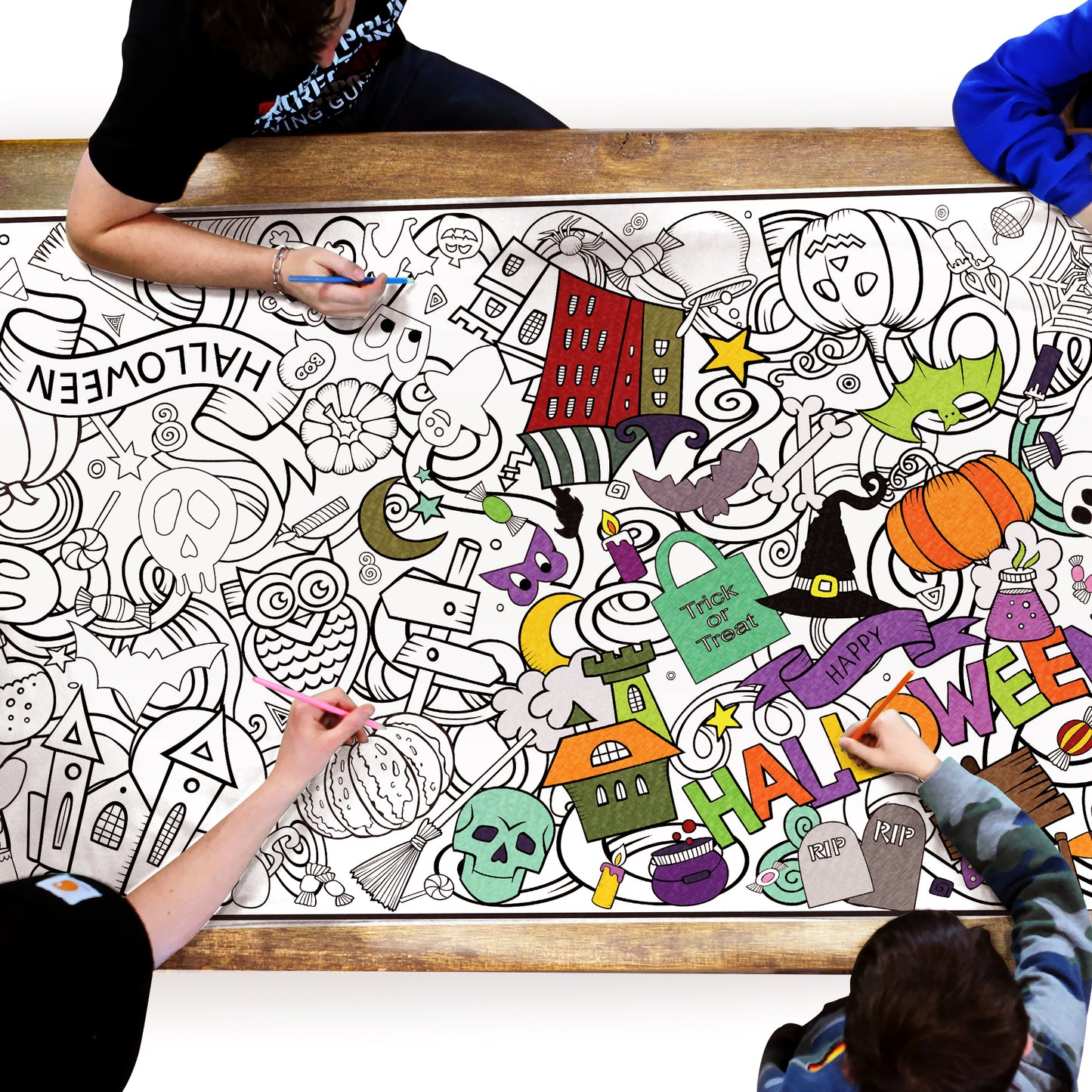 group of people coloring a halloween themed coloring sheet on a table