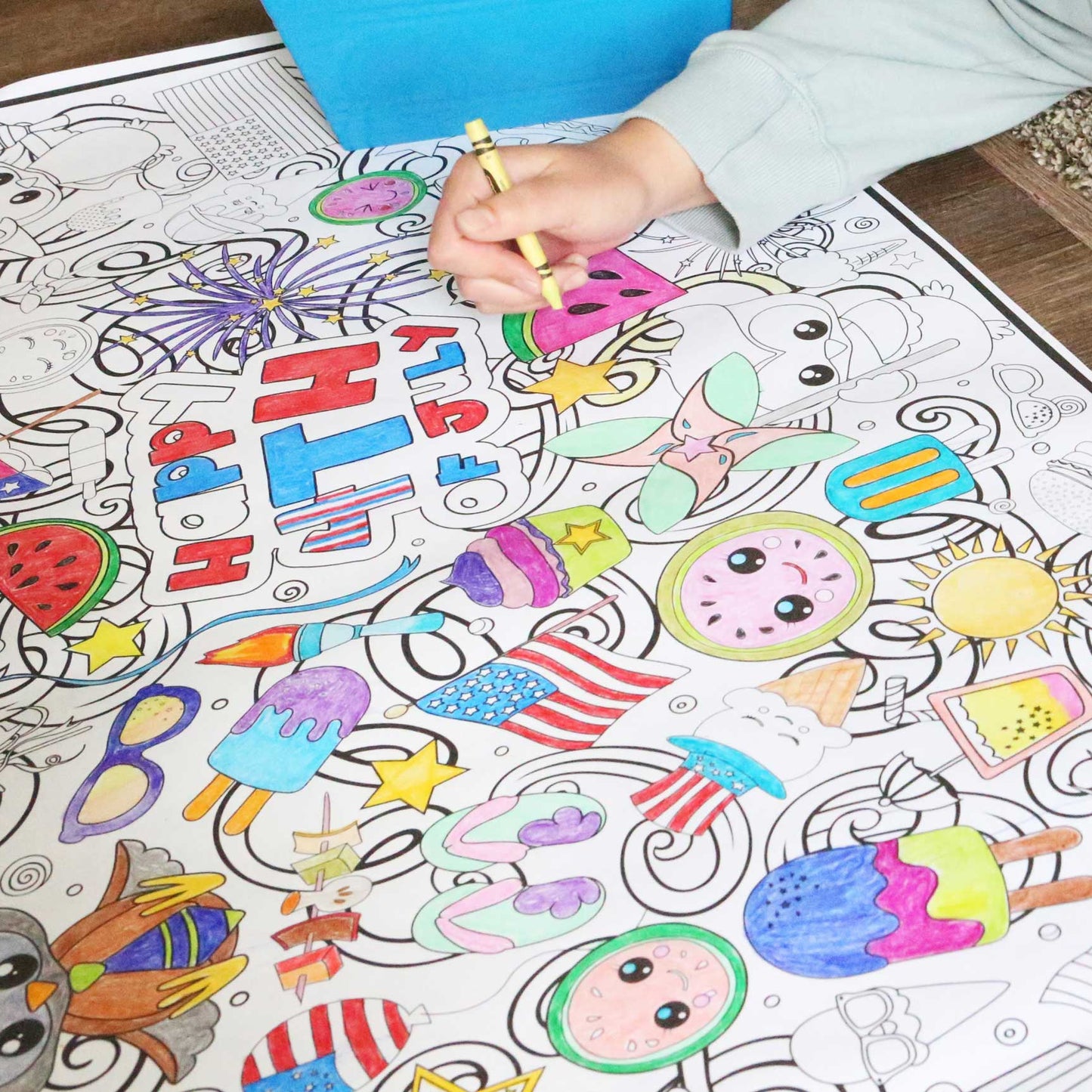 Person coloring a detailed coloring book with various illustrations on a wooden table.
