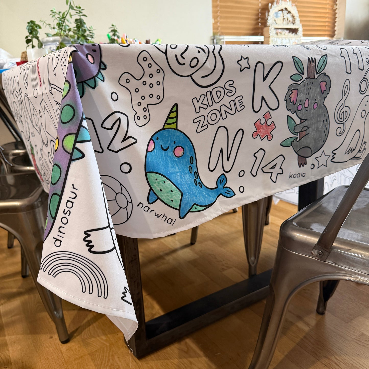 Coloring Fabric coloring tablecloth with cartoon designs on a table with a chair