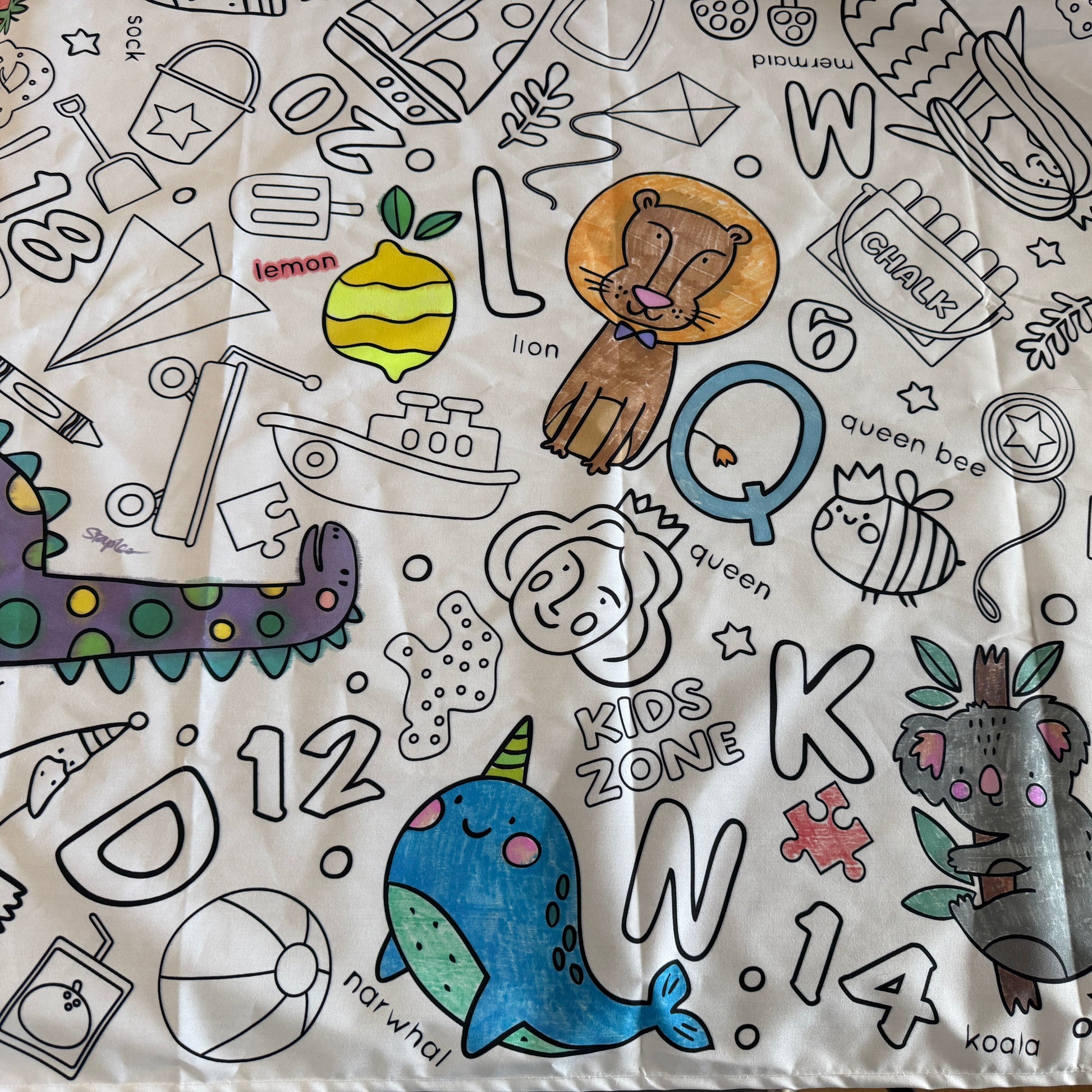 Coloring tablecloth with various preschool illustrations and letters.