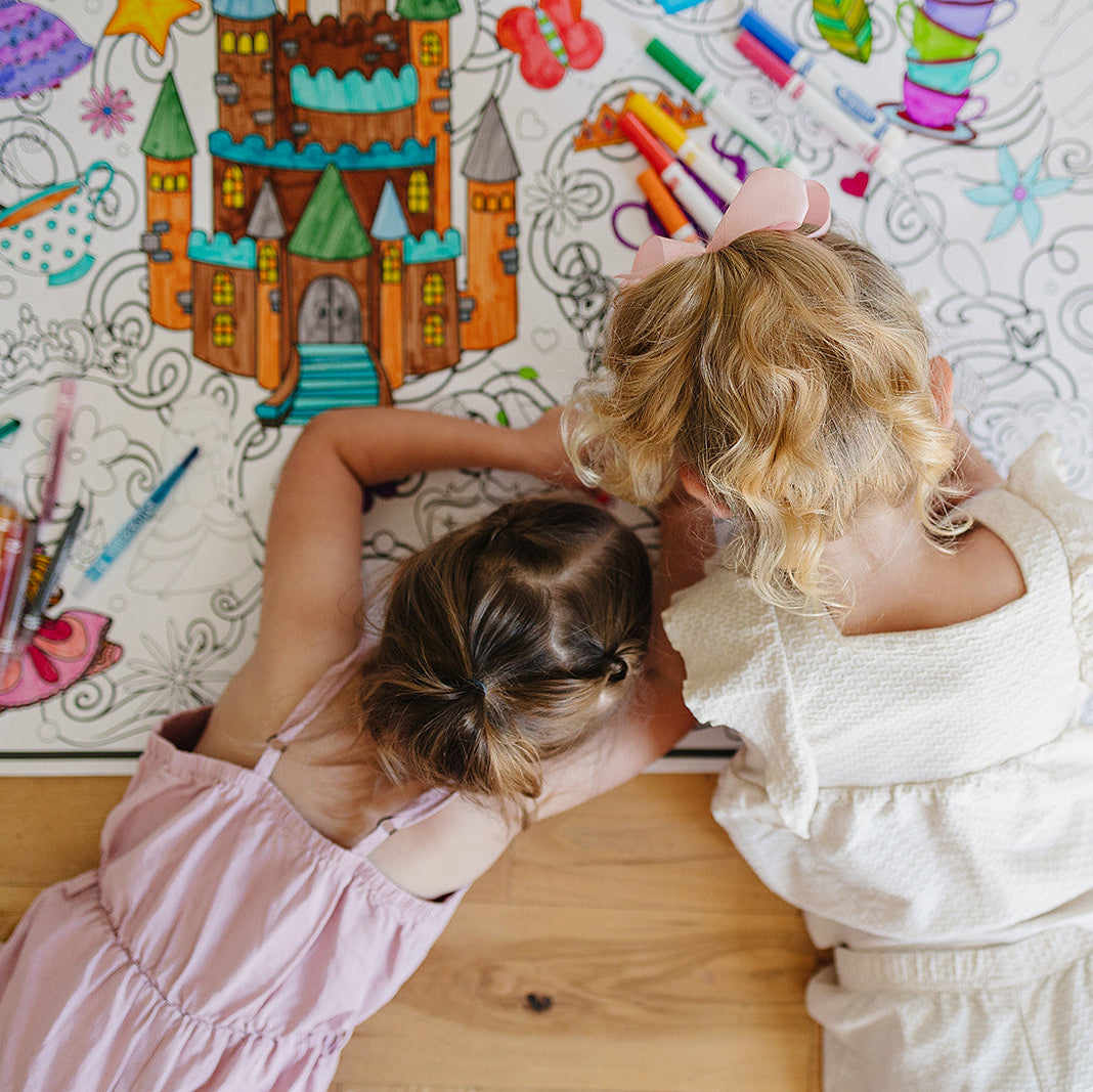 Two children coloring a princess coloring poster with markers and twistable crayons.