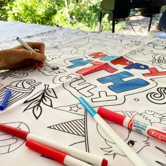 Coloring tablecloth with markers on a table outdoors