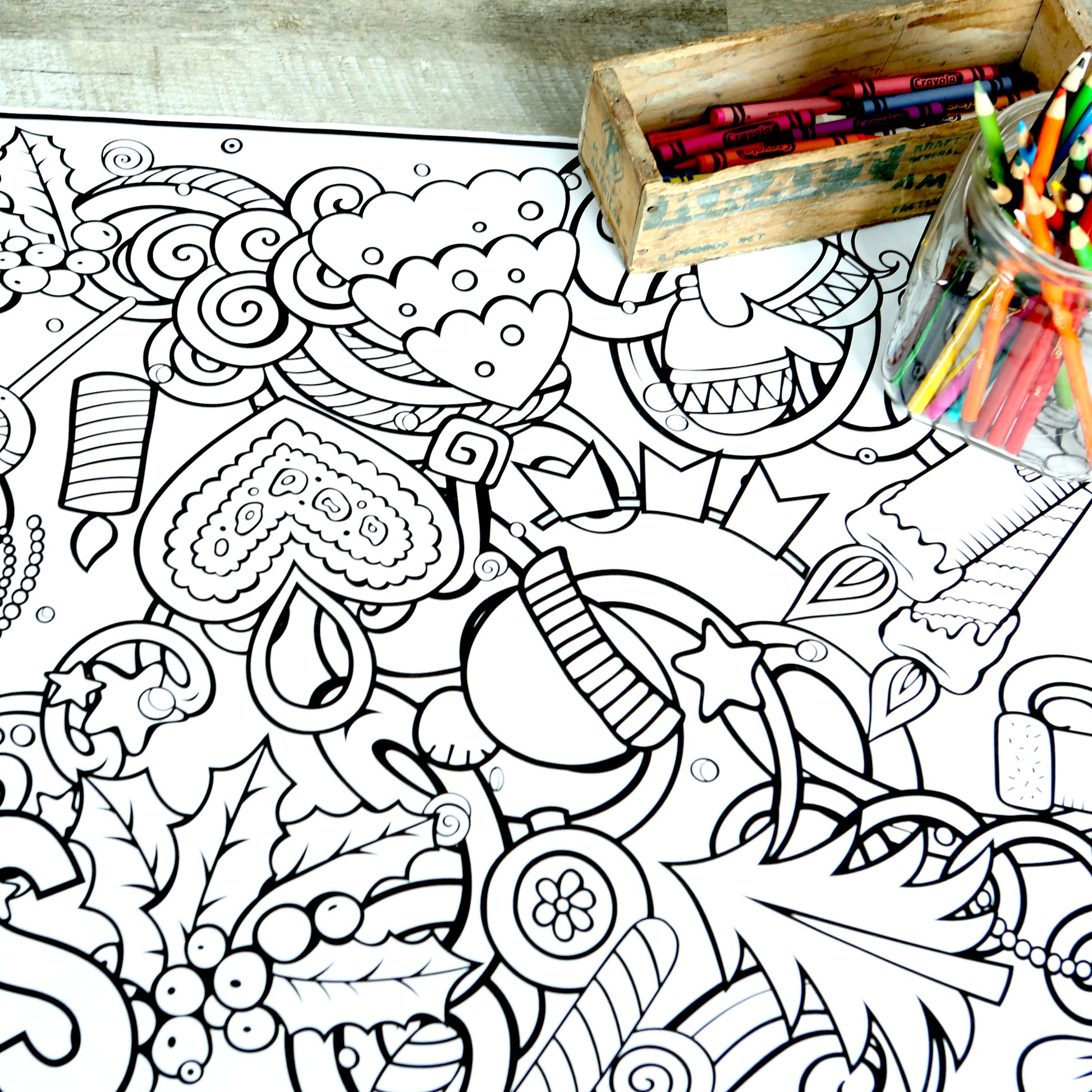 Coloring banner with Christmas designs all over it. Holly berries, a Christmas tree, candles, a star, hearts, ornaments and a box of colored pencils.
