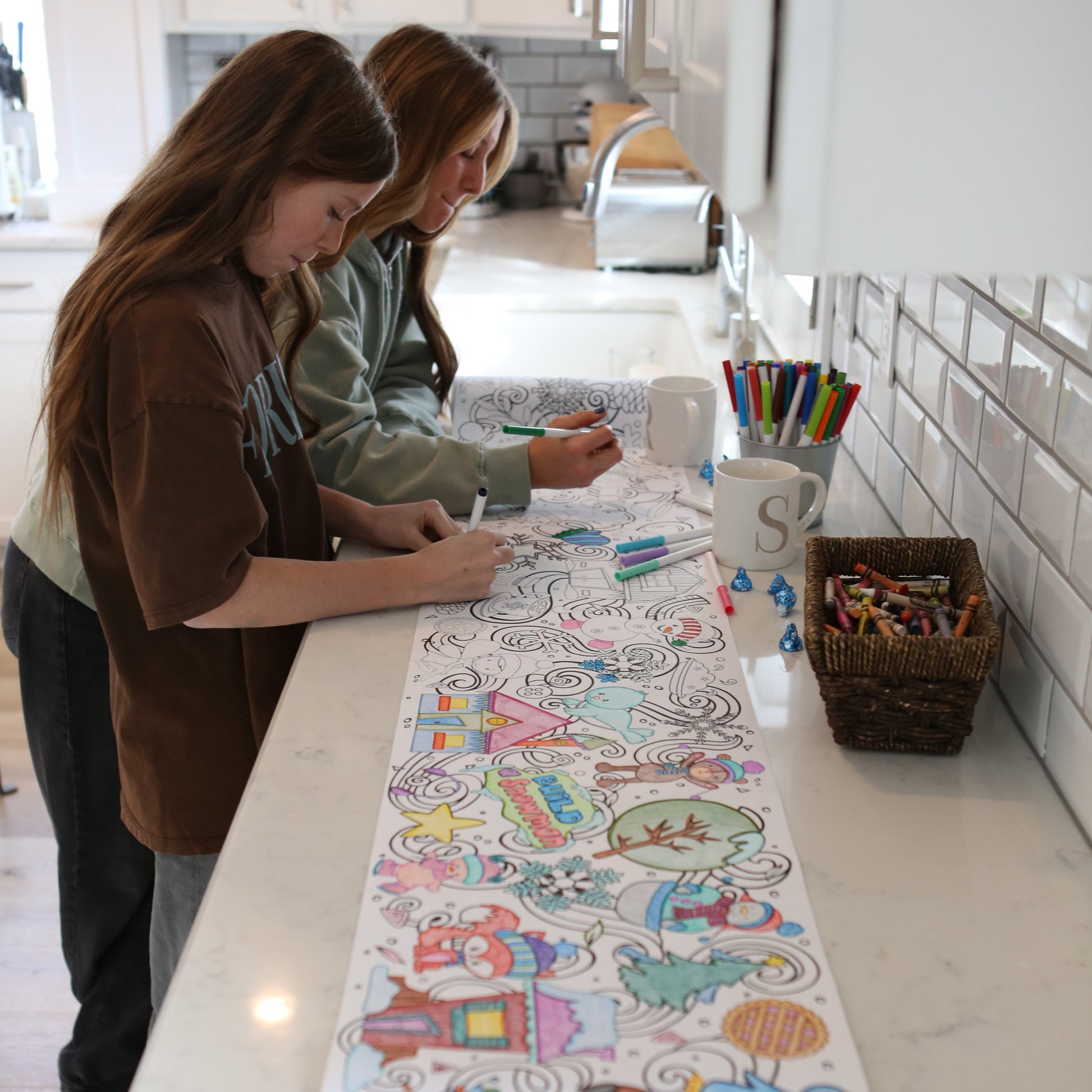 two girls coloring a long coloring sheet with winter themed graphics on it - by Artistic Chaos Ink. 