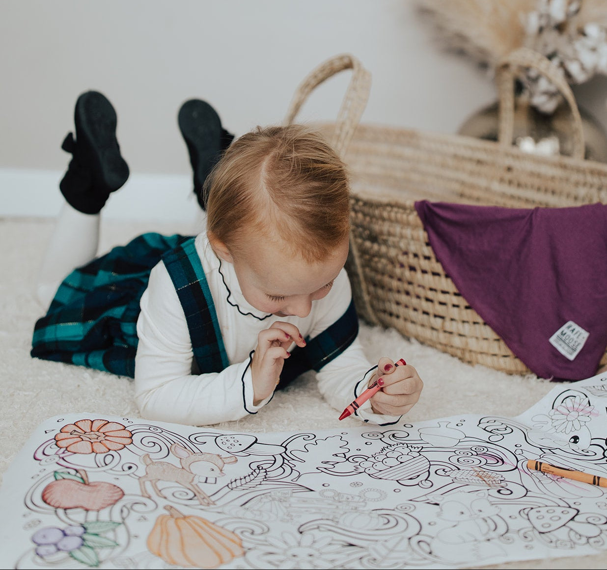 little girl coloring fall themed coloring roll. Holding a red crayon