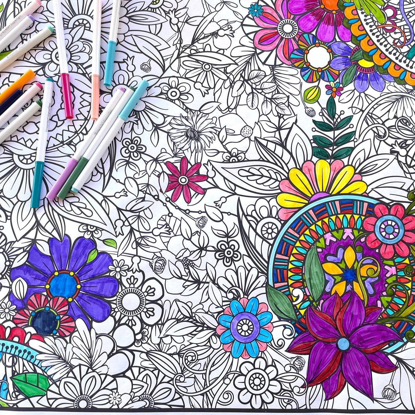 flower coloring banner partially colored with markers laying on top of the sheet