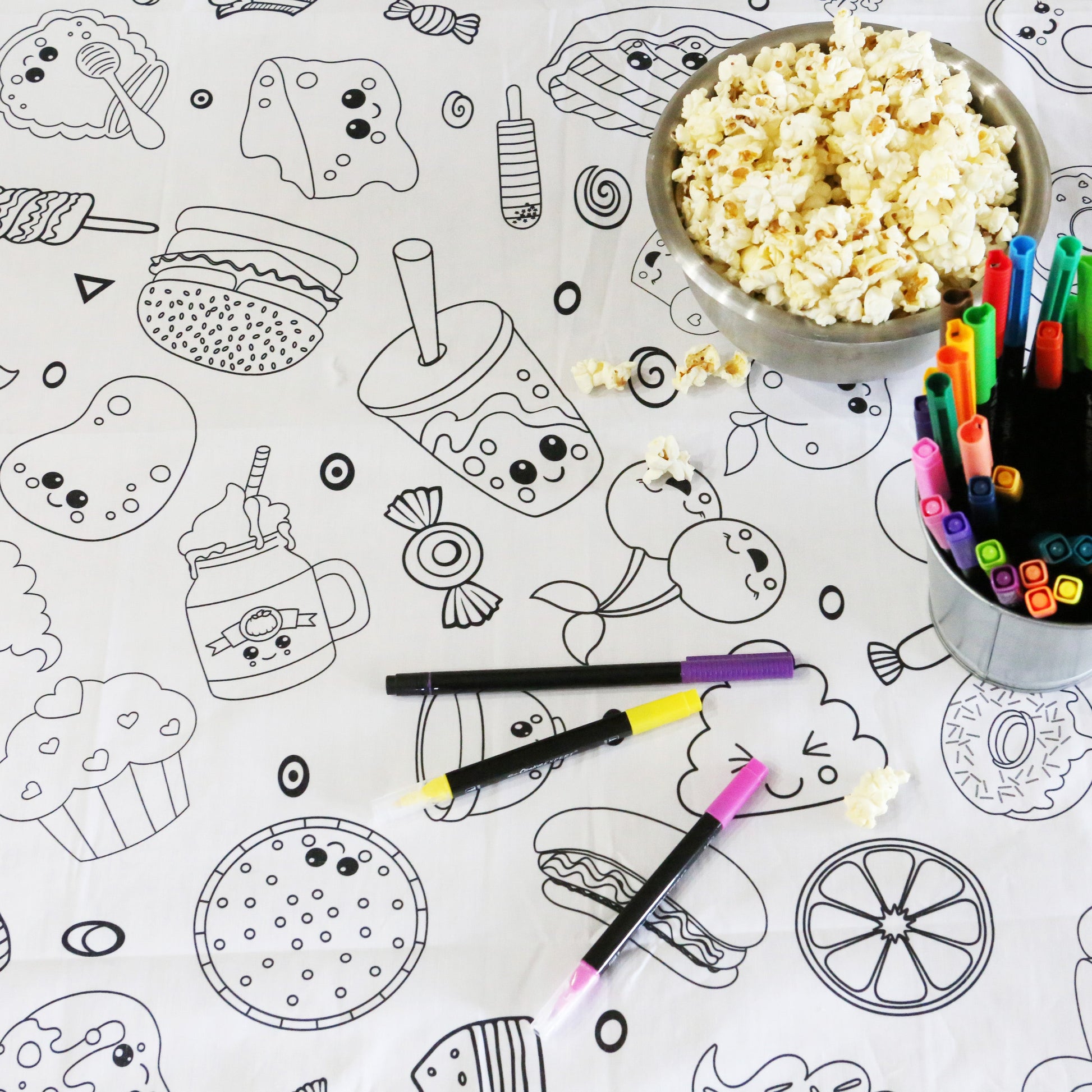 Artistic Chaos Ink Fabric Coloring Tablecloth with silly fun food images, popcorn and bright colored washable markers.
