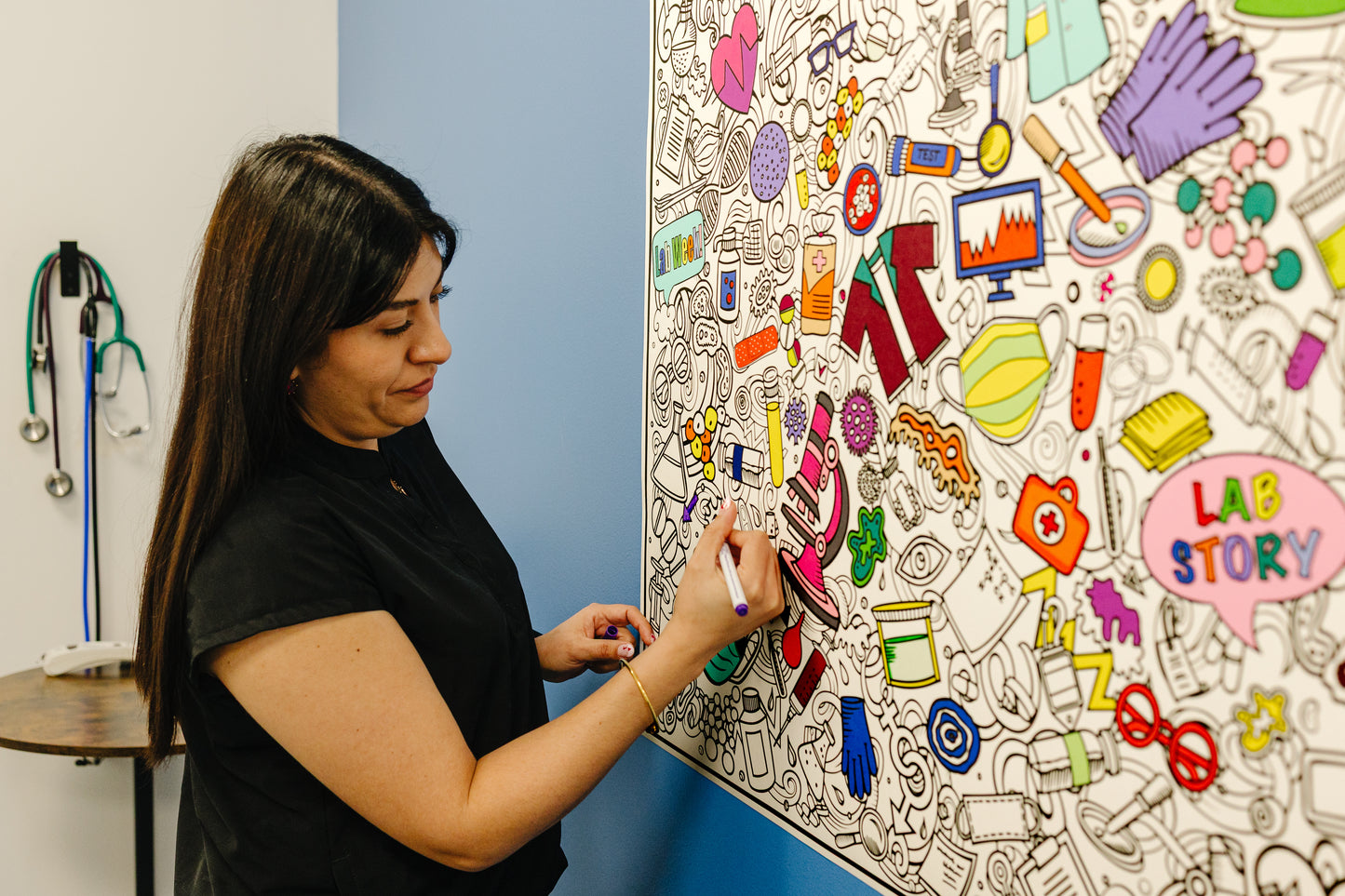 Person interacting with a coloring poster on a wall in an lab setting