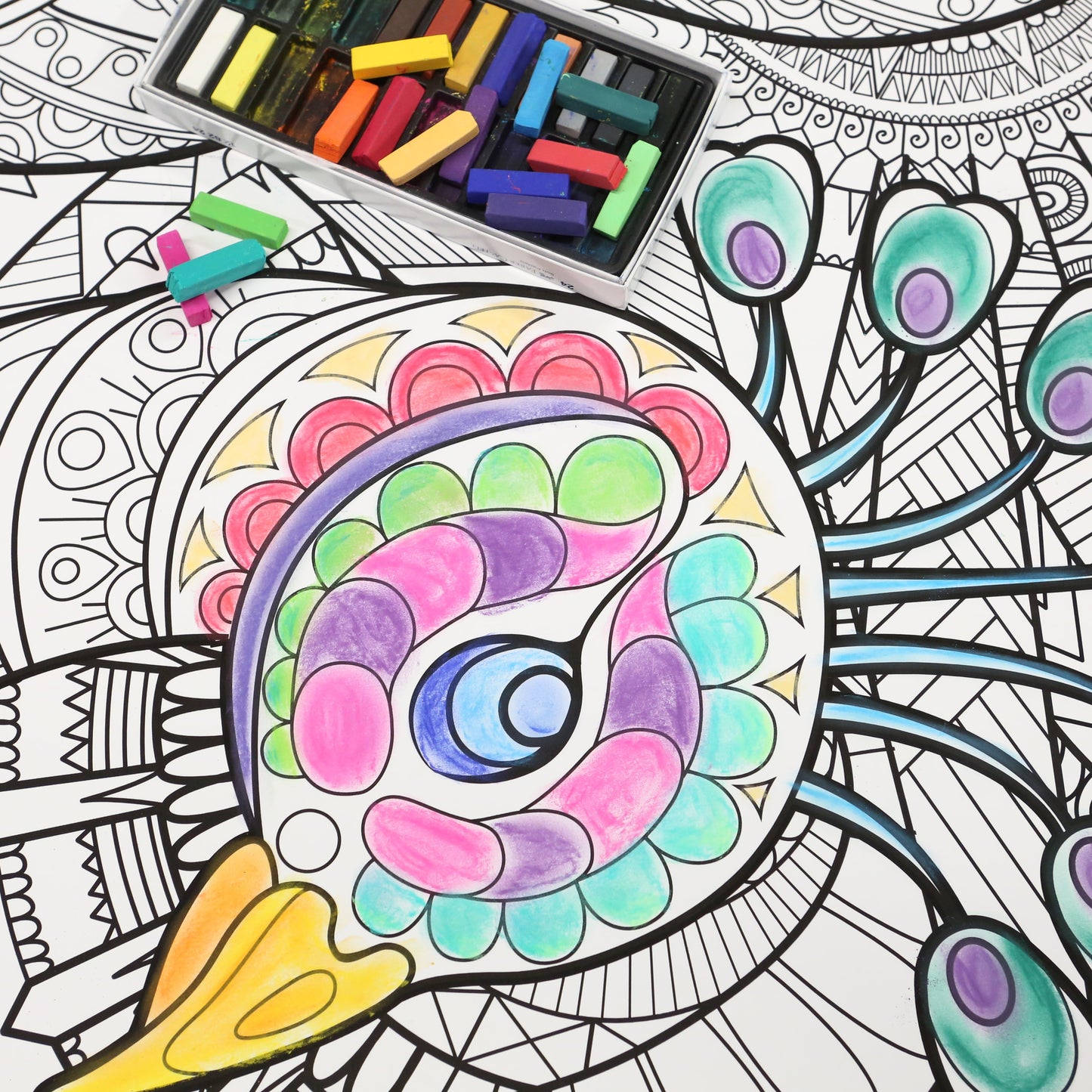 brightly colored peacock with a box of chalk pastels sitting near it. 