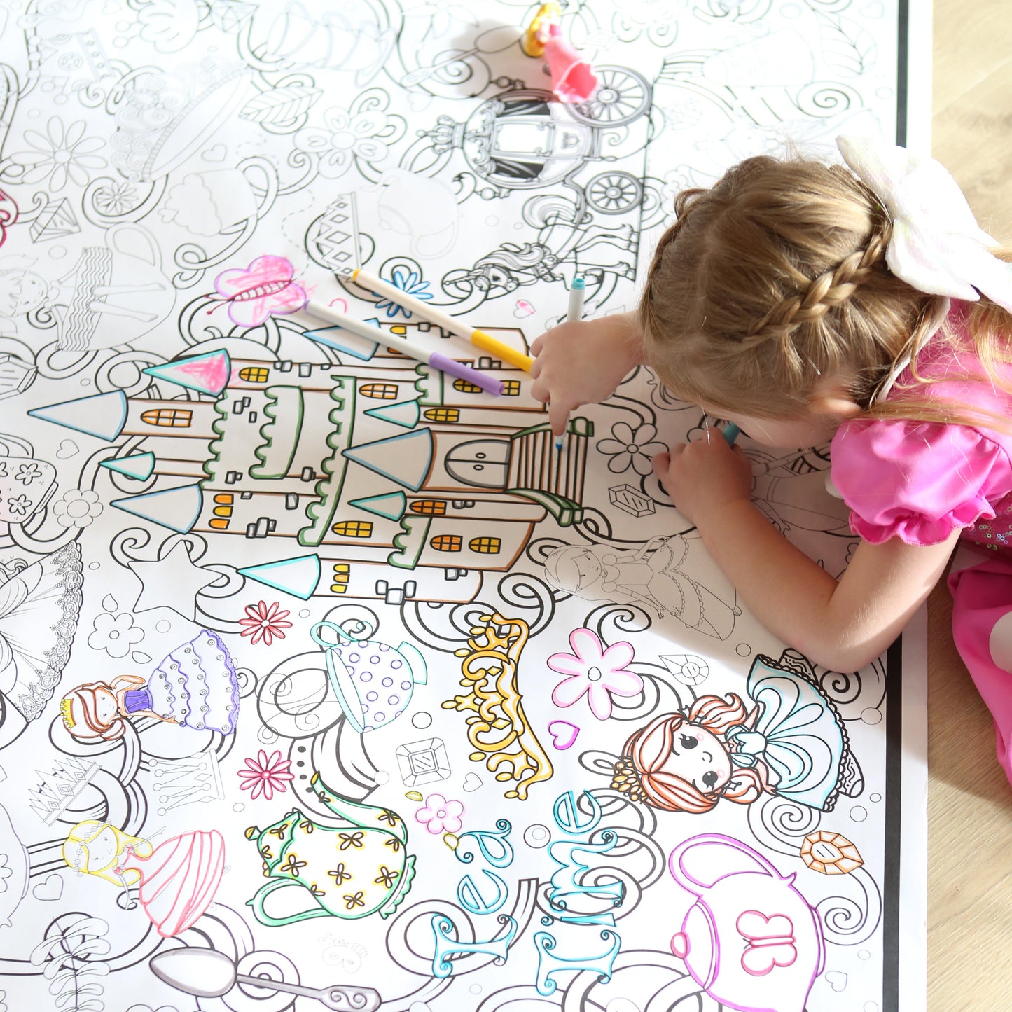 Child coloring on a large, detailed coloring page with a castle design by Artistic Chaos Ink