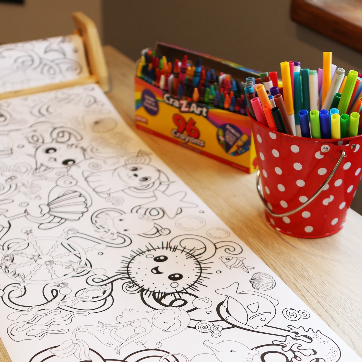 Long Coloring Sheet with under water ocean graphics and images, crayons, and markers on a table
